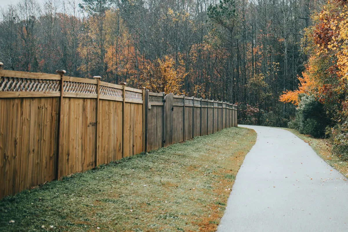 Cedar privacy fence with a lattice top running along a walking path
